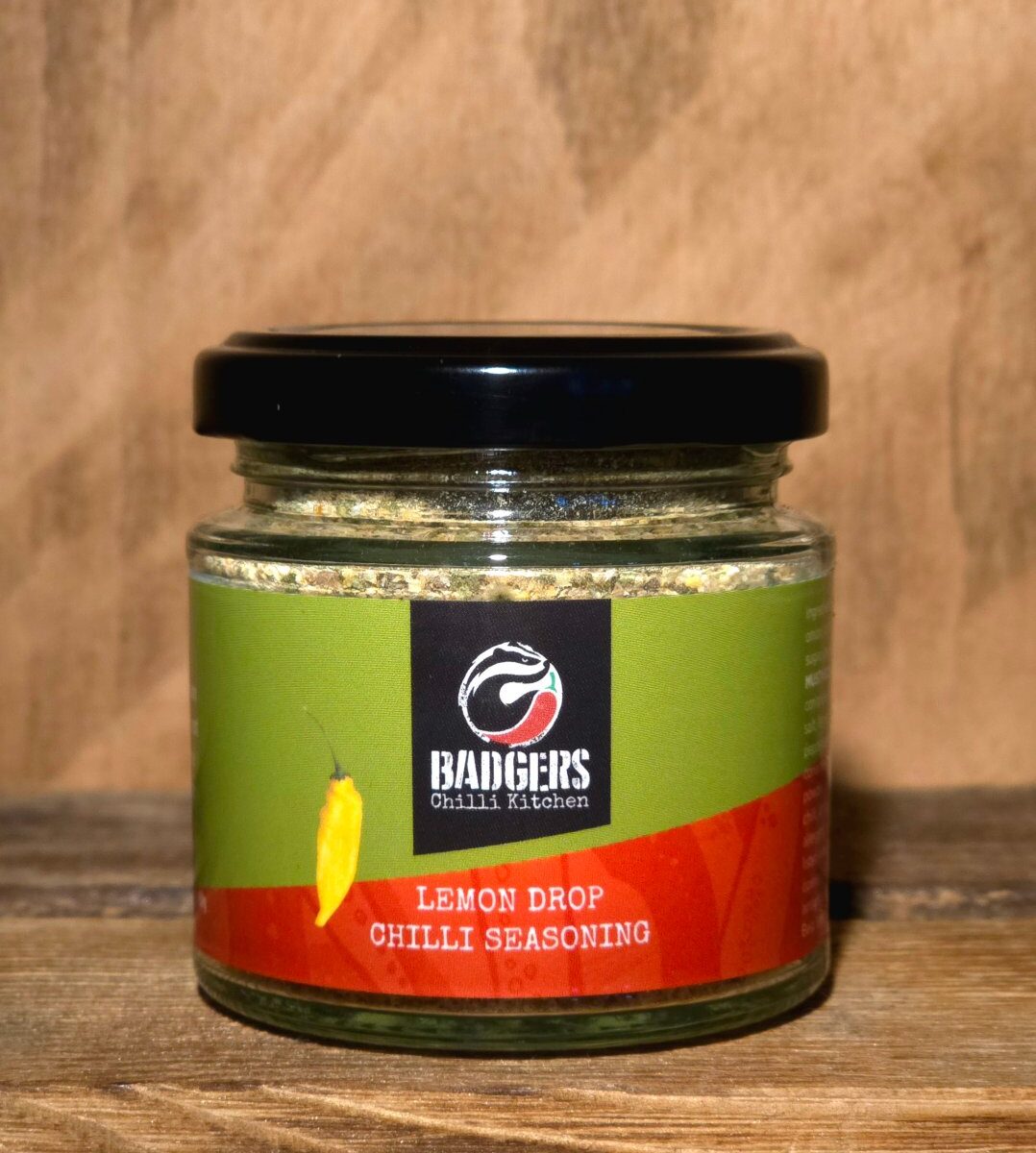 A jar of lemon drop chilli seasoning with a green and red label and black lid